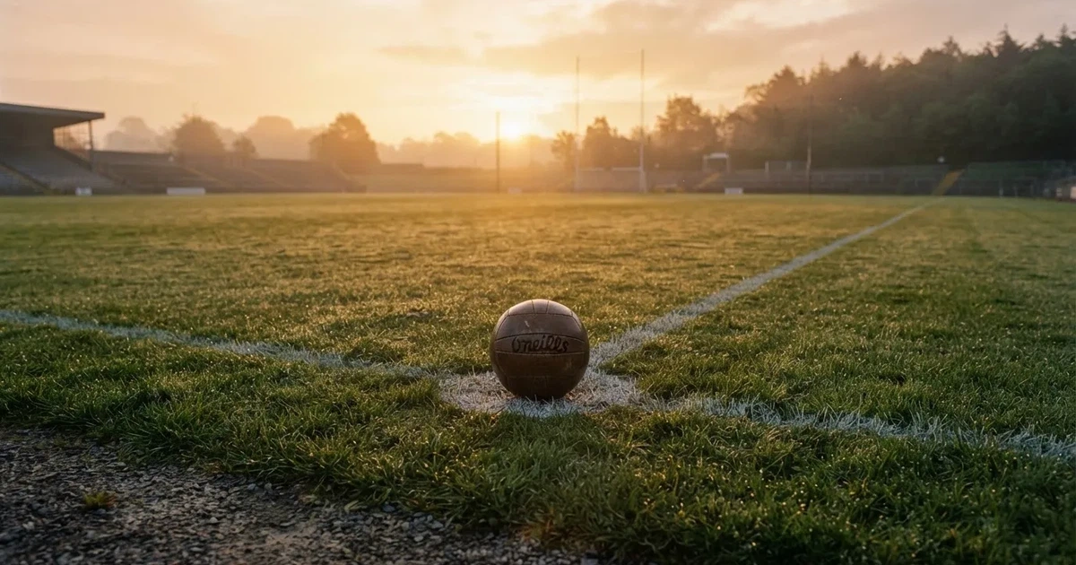 A ball on the centre spot of a grass pitch in morning light